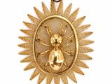 une image représentant un pendentif en or orné d'une abeille