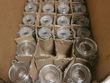 a cardboard box full of empty glass jars on a table