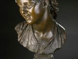 bronze bust of a woman with a head of hair on a pedestal