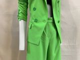 the mannequin is wearing a bright green suit and black top