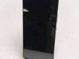 the back of a black cell phone sitting on top of a white table