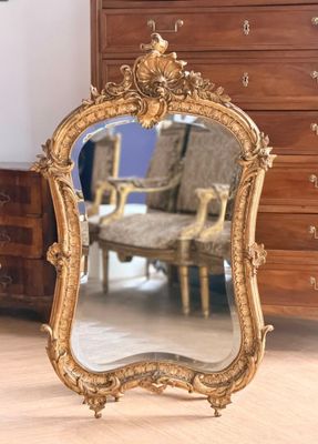 un miroir posé sur le sol devant une commode