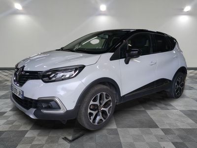 a white car is parked on a checkered floor in a garage