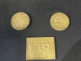 three gold coins sitting on top of a black cloth next to each other