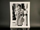 a black and white photo of a man in a trench coat