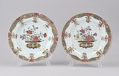 une paire d'assiettes chinoises ornées de motifs floraux, présentées sur un présentoir