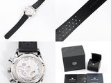 a watch that is sitting next to a watch box and a watch strap