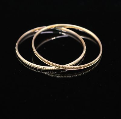 a pair of gold hoop earrings on a black surface