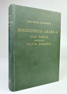 un vieux livre à la couverture verte posé sur une table blanche