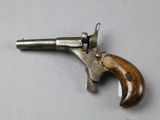 an old gun with a wooden handle on a white surface