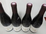 four bottles of wine are lined up on a table