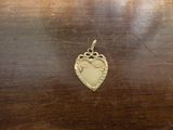 un petit pendentif en forme de cœur posé sur une table en bois