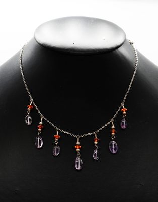 un collier composé de perles violettes et orange, porté par un mannequin