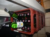 bottles of wine are in a red crate on a counter