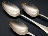 three spoons that are sitting on a table