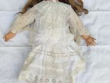 three dolls laying next to each other on a white sheet