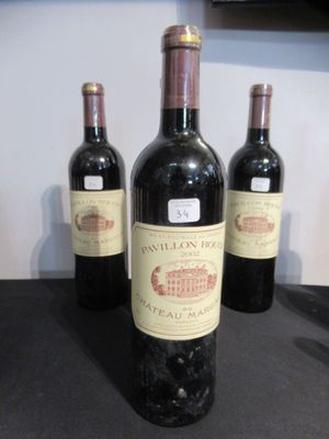 trois bouteilles de vin sont alignées sur un plan de travail