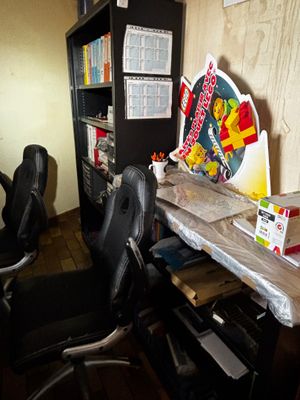 un bureau avec une chaise et une étagère dans le coin