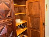 a large wooden cabinet with shelves in the corner of the room