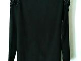 the back of a black sweater with silver studding on it