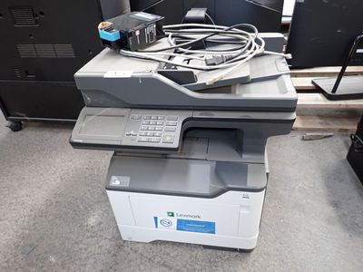 une imprimante posée sur un bureau, à côté d'un écran