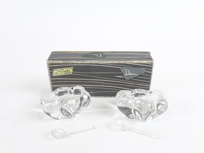 une paire de bougeoirs en verre transparent en forme de cœur, présentés dans un coffret cadeau