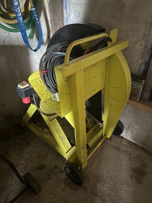 un chariot jaune équipé d'un tuyau, dans un garage