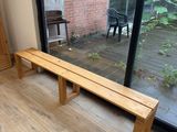 a wooden bench sitting in front of a glass door