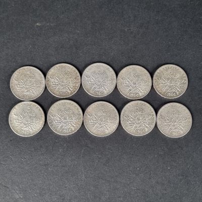 six pièces d'argent sont disposées en rangée sur une surface noire