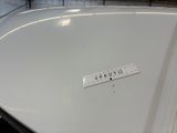 a close up of a white car with a ruler on the hood