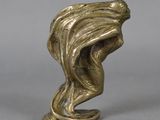 a bronze figurine of a woman ' s head with flowing hair