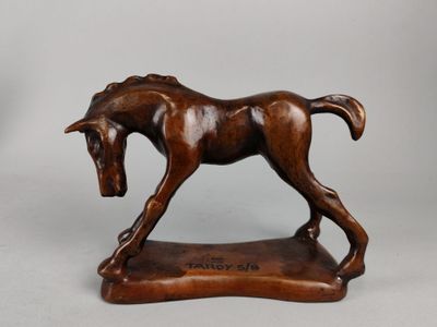 statue d'un cheval posée sur un socle en bois, sur fond blanc