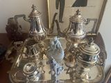 a silver tray with silver tea and coffee set on it