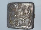 a silver box with a design on it on a white surface