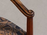 a close up of a wooden chair with a floral pattern on it