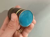 a person holding a small blue object in their hand