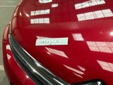 a close up of a red car with a sticker on it ' s hood
