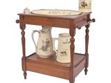 a wooden table with two mugs and a vase on it