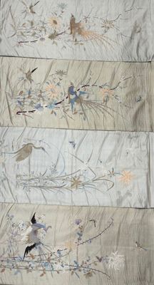 une photo d'un morceau de tissu orné d'oiseaux et de fleurs