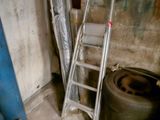 a ladder leaning against a wall next to a tire