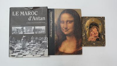 three books on a white table with a picture of a painting and a picture of a woman