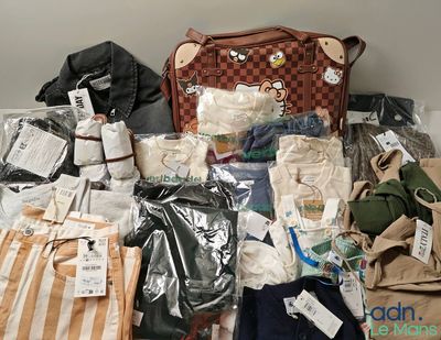 un tas de vêtements et un sac à main posés sur un lit