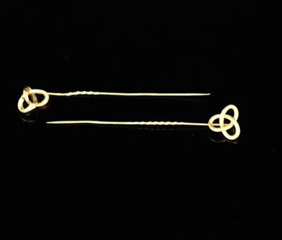 a pair of gold plated hair pins with a knot design
