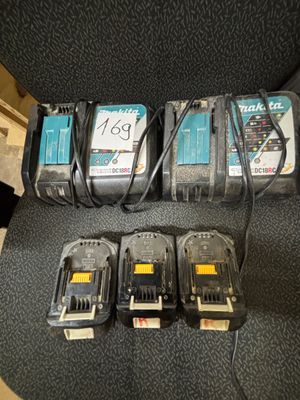 quatre batteries Makita et un chargeur posés sur une chaise