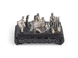 une figurine en argent représentant un groupe de personnes, posée sur une table