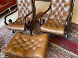 deux fauteuils en cuir marron et un pouf marron dans un salon