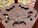 a wooden chair that has a flower design on it