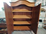 a large wooden cabinet with shelves in the middle of the room