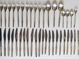 many forks and spoons laid out on the table