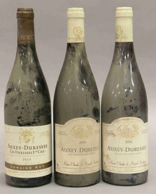 trois bouteilles de vin posées l'une à côté de l'autre sur une table